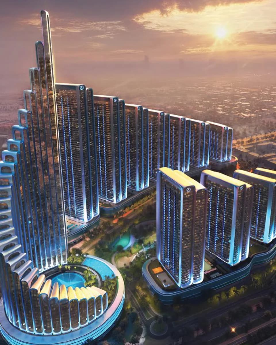 Mercedes-Benz Places Binghatti City: aerial view of an illuminated curved tower development at dusk — rendering