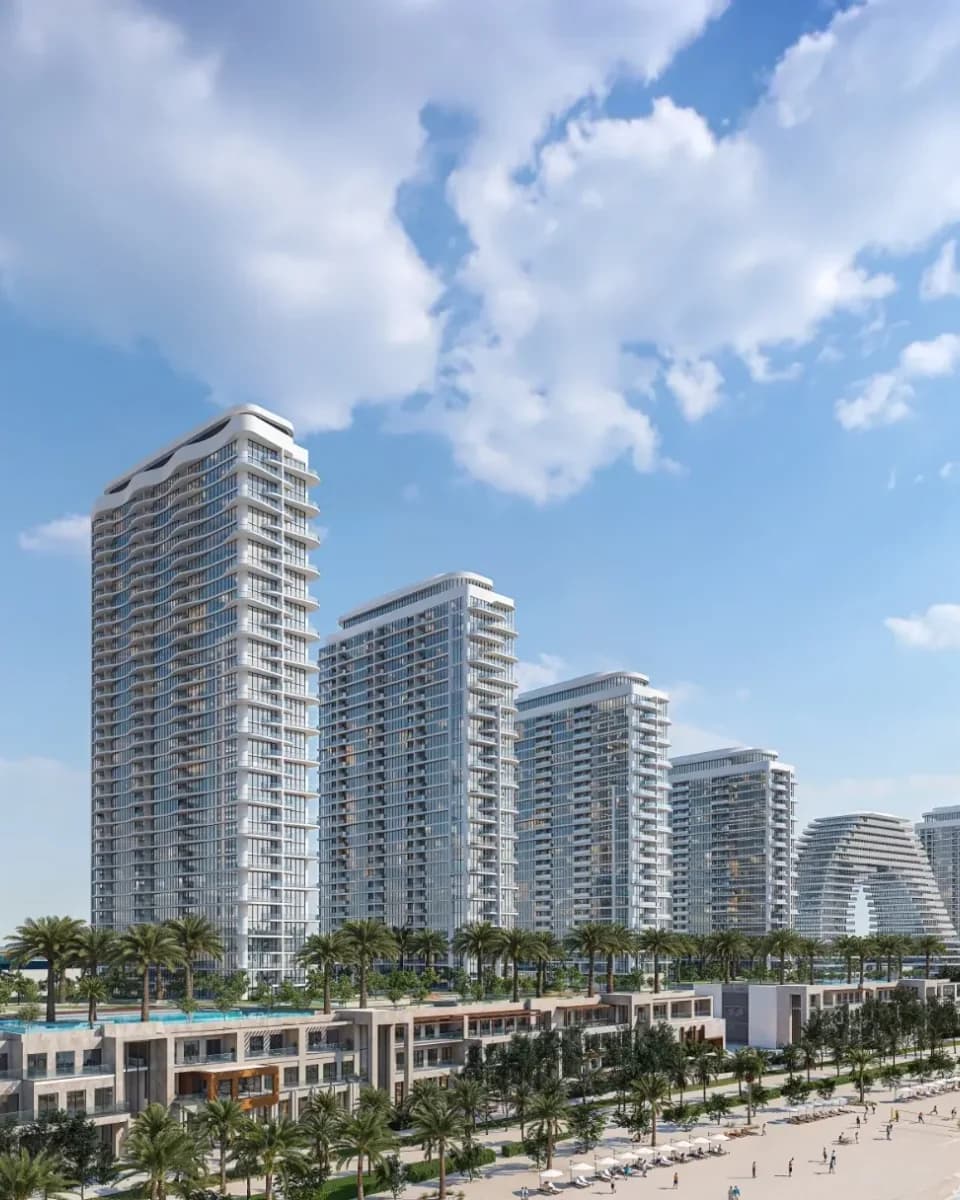 Waterfront residential towers above a landscaped promenade and beach; official developer rendering