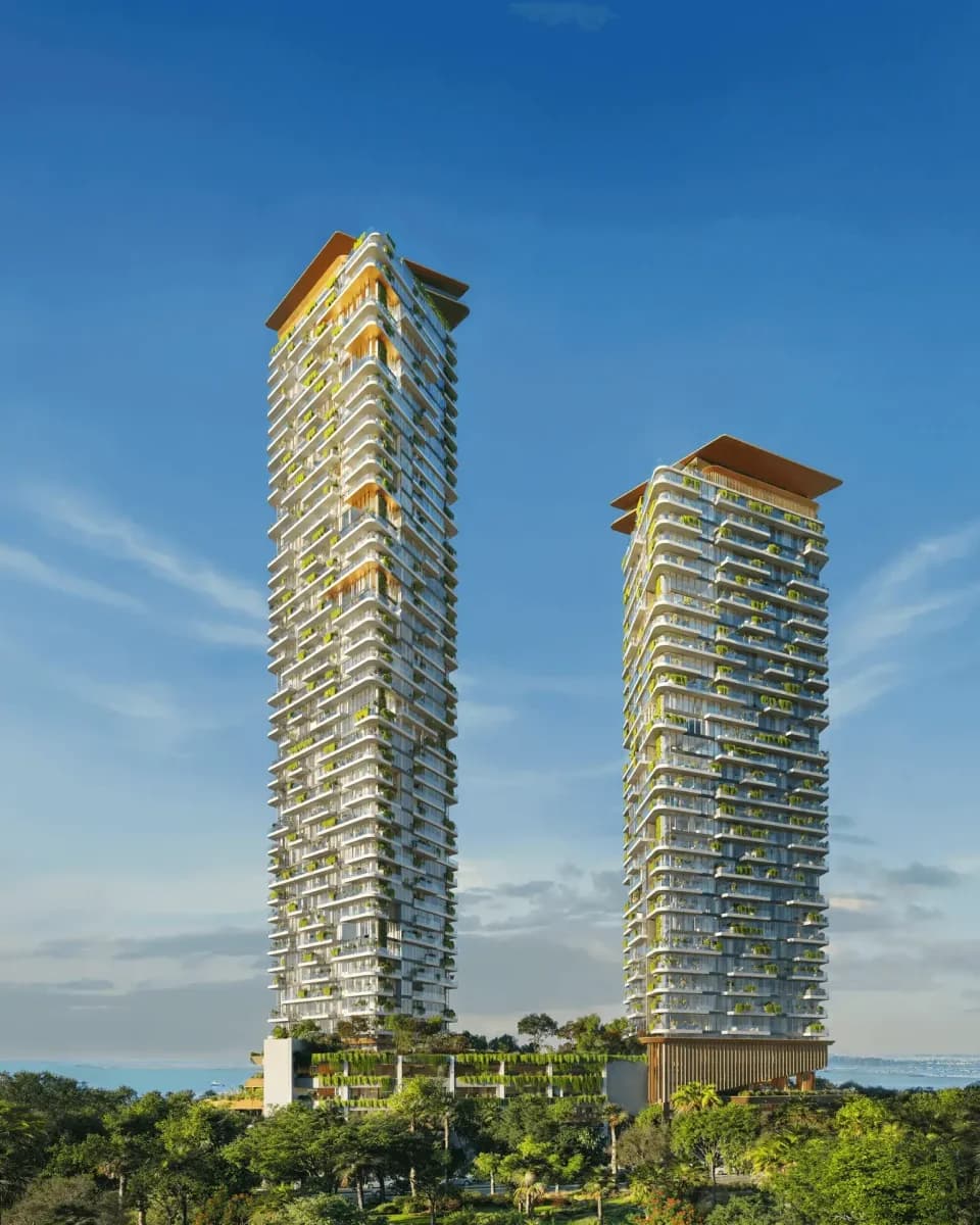 Two residential towers with planted balconies above a landscaped podium; official developer rendering