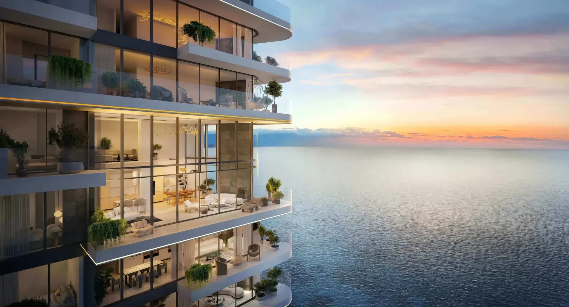Planted balconies and glazed living spaces overlooking the sea at sunset; official developer rendering