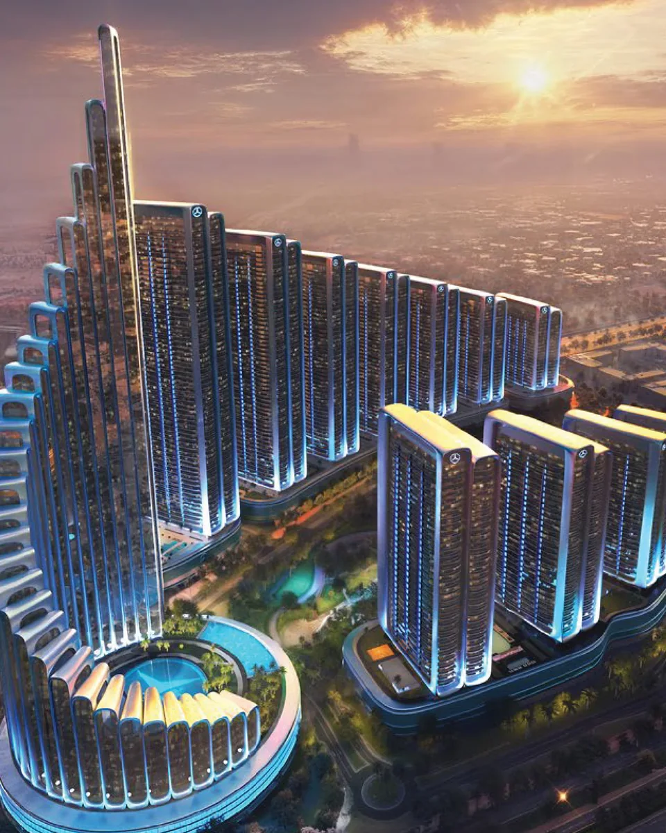 Mercedes-Benz Places Binghatti City: aerial view of an illuminated curved tower development at dusk — rendering
