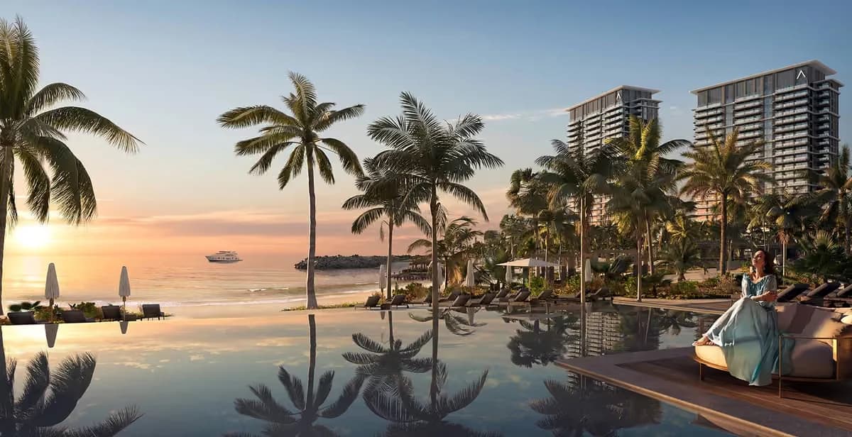 Beachfront pool terrace and residential towers at sunset; official developer rendering
