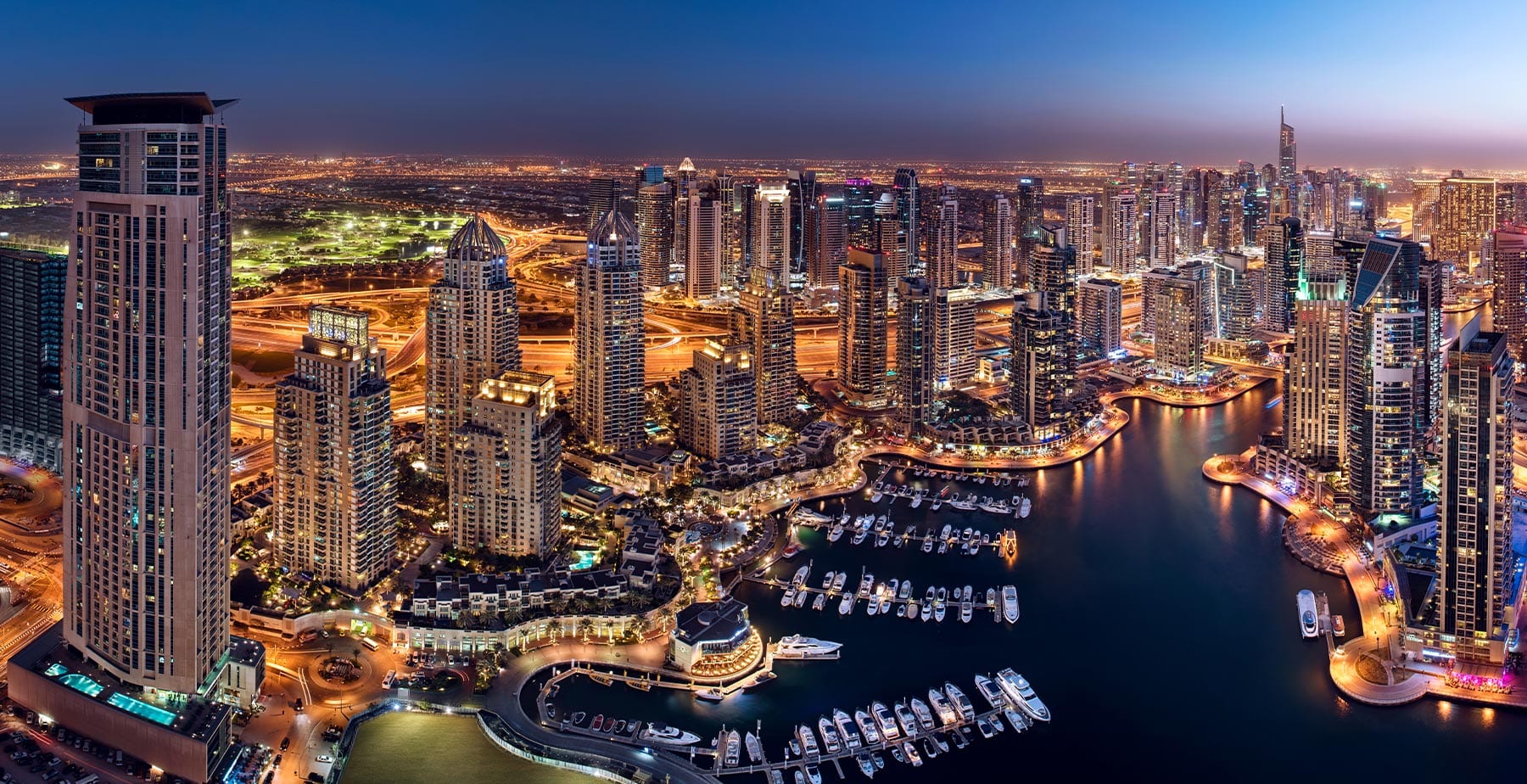 Dubai Marina waterfront and illuminated towers at night, official Emaar community image. Illustrative Dubai property context.